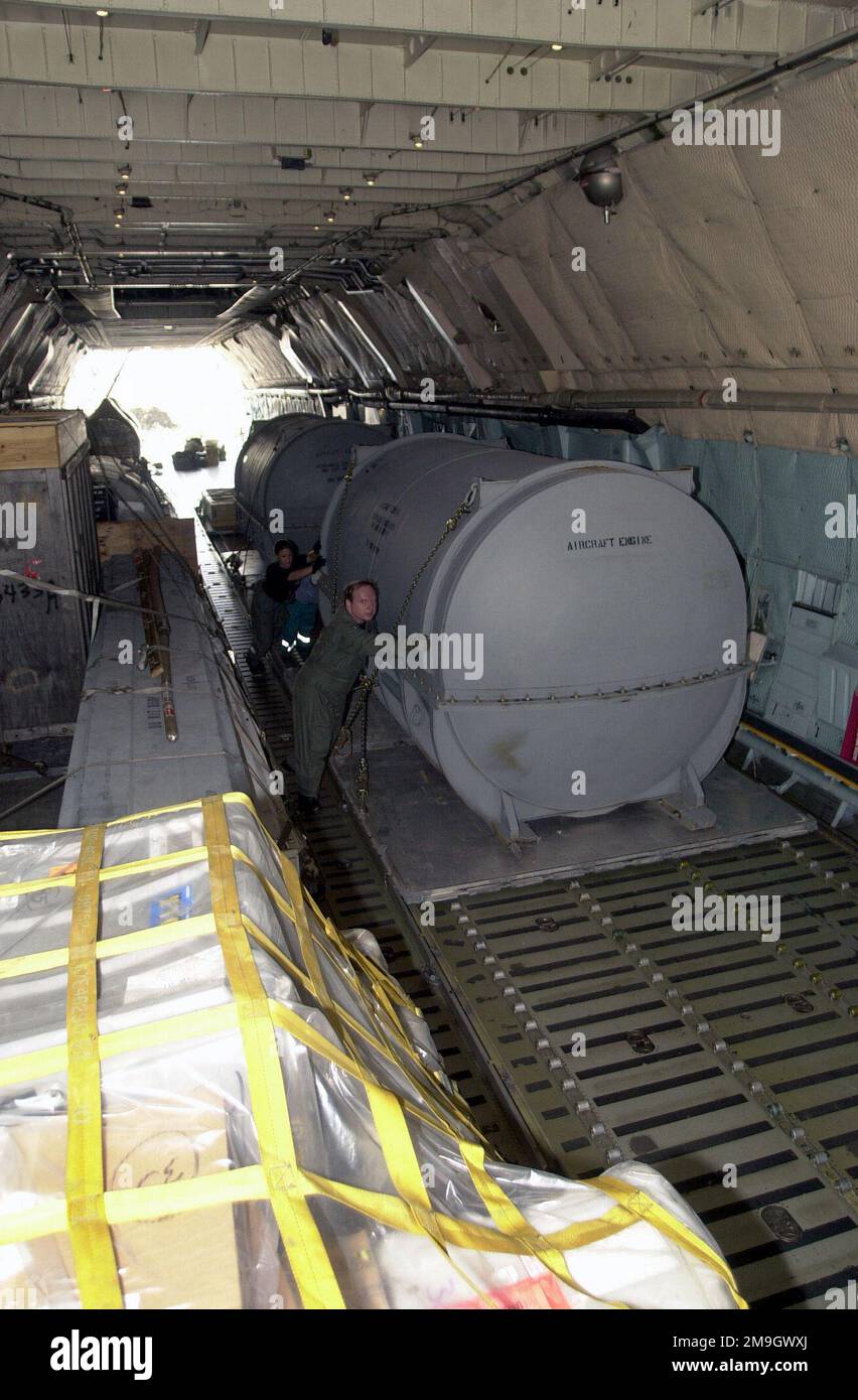 A C-5A Galaxys crew, assisted by local Italian workers, push crated aircraft engine toward the rear of the aircraft. The engines will be unload onto a K-loader at the rear of the aircraft at Naval Air Station (NAS) Sigonella, Sicily, during Operation ENDURING FREEDOM. In response to the terrorist attacks on September 11, 2001 at the New York World Trade Center and the Pentagon, President George W. Bush initiated Operation ENDURING FREEDOM in support of the Global War on Terrorism (GWOT), fighting terrorism abroad. Subject Operation/Series: ENDURING FREEDOM Base: Naval Air Station, Sigonella St Stock Photo