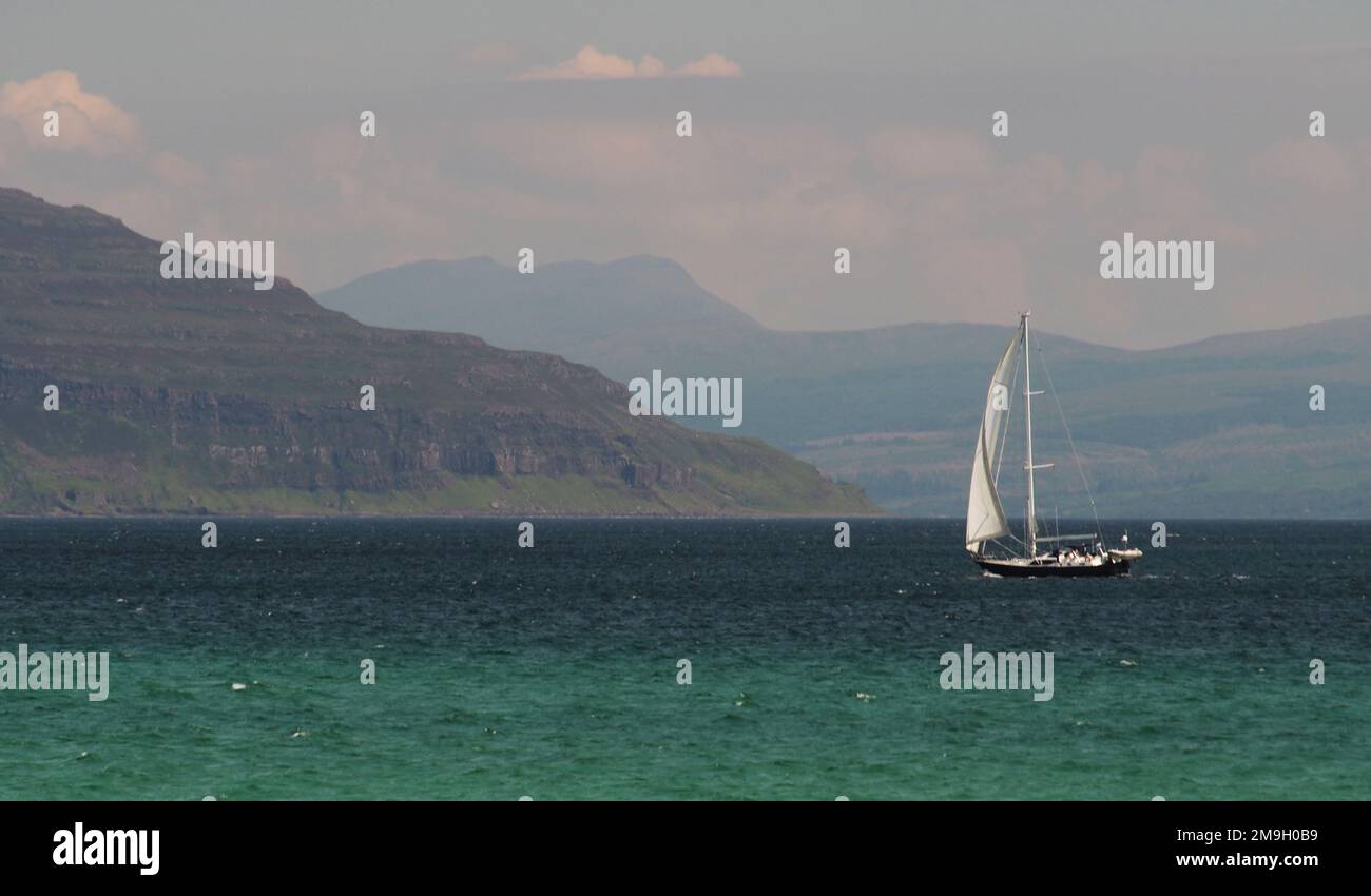 A yacht sailing in the Sound of Iona with an aquamarine sea and the