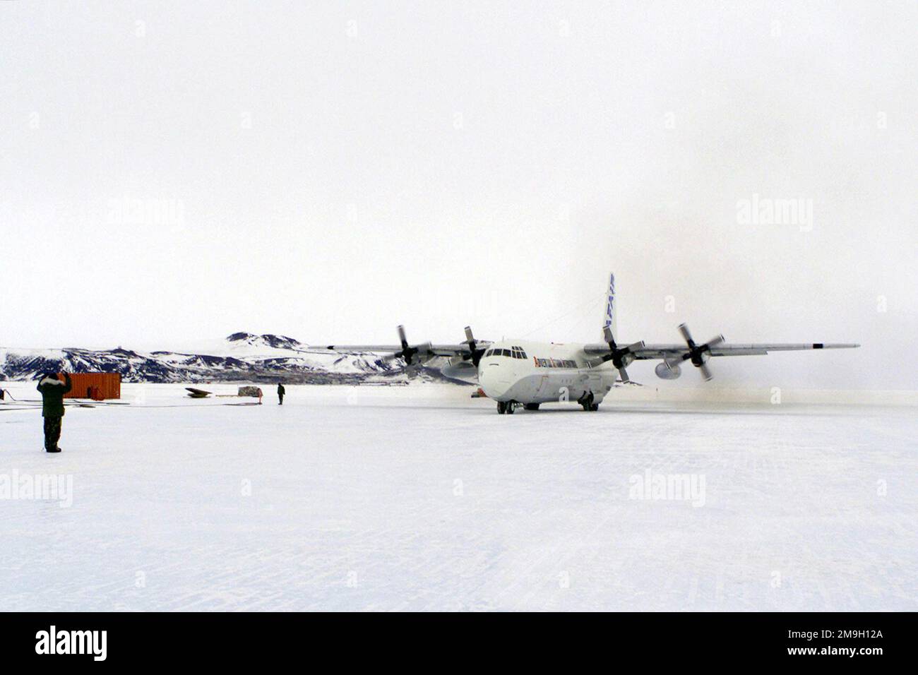 A Lockheed C-130G shown taxiing on the ice pack with McMurdo Station in ...