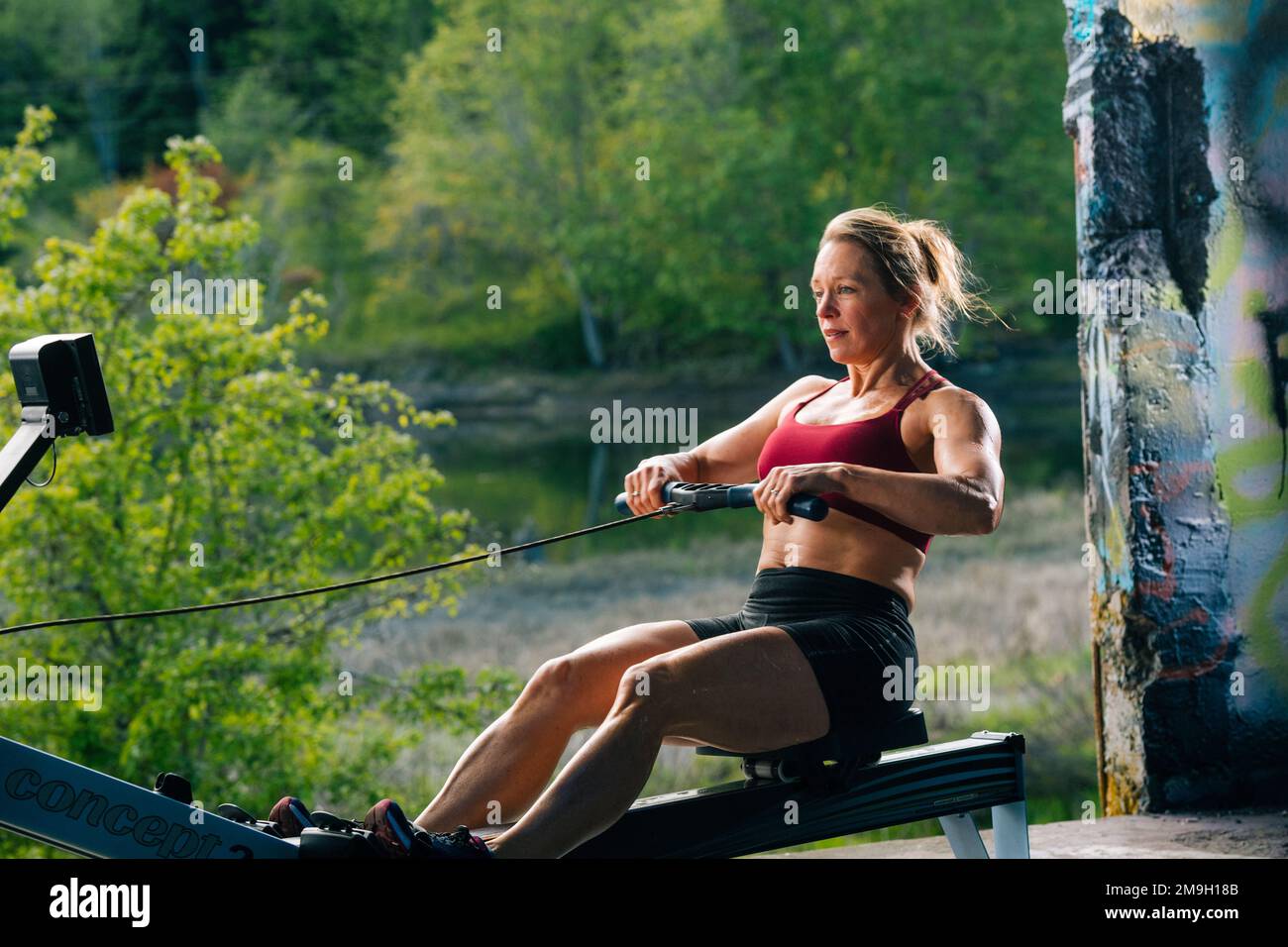 Woman exercising on rowing machine outdoors, Bainbridge Island, Washington, USA Stock Photo