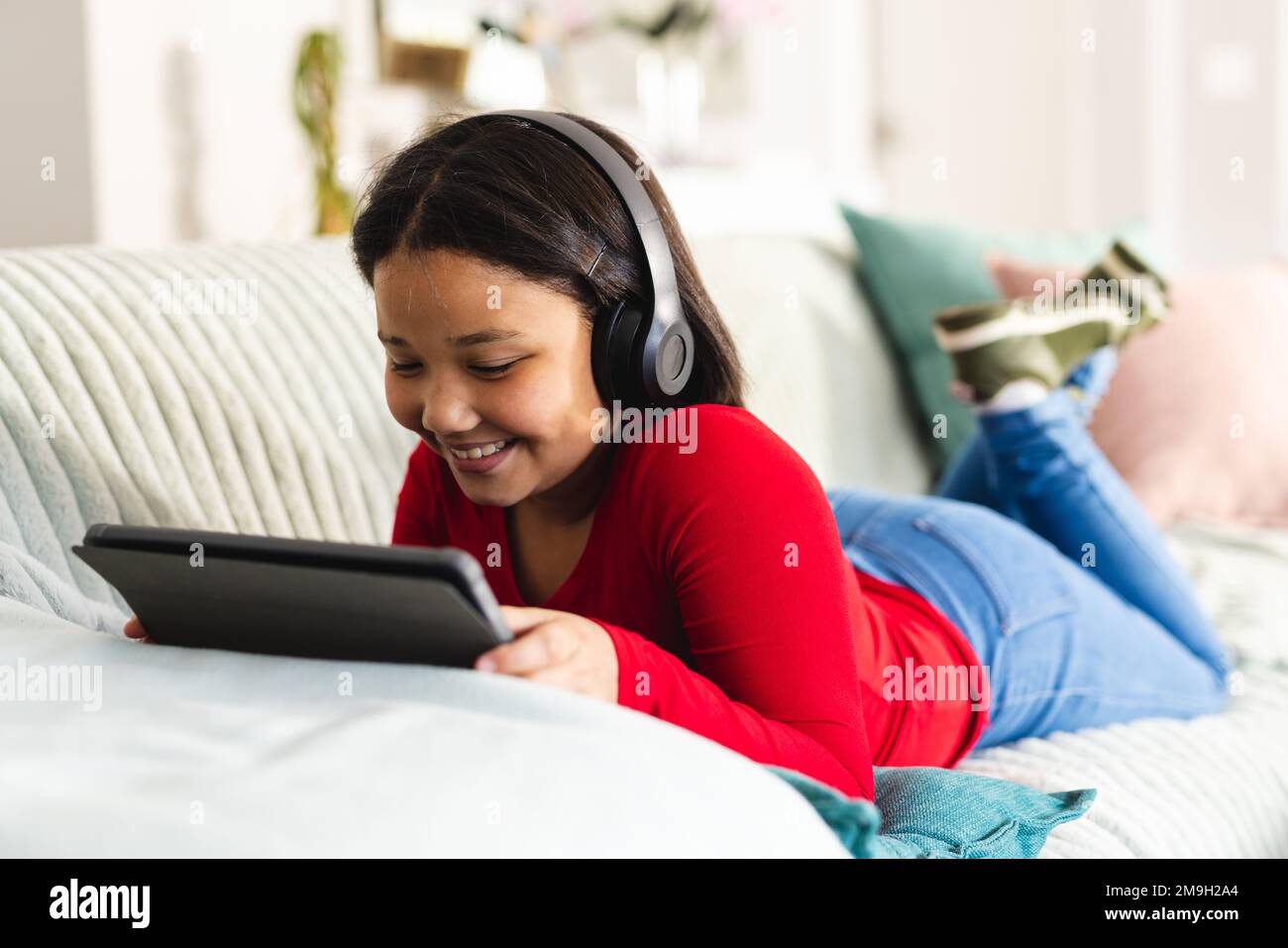 Happy asian girl sitting on sofa in living room and using tablet Stock ...