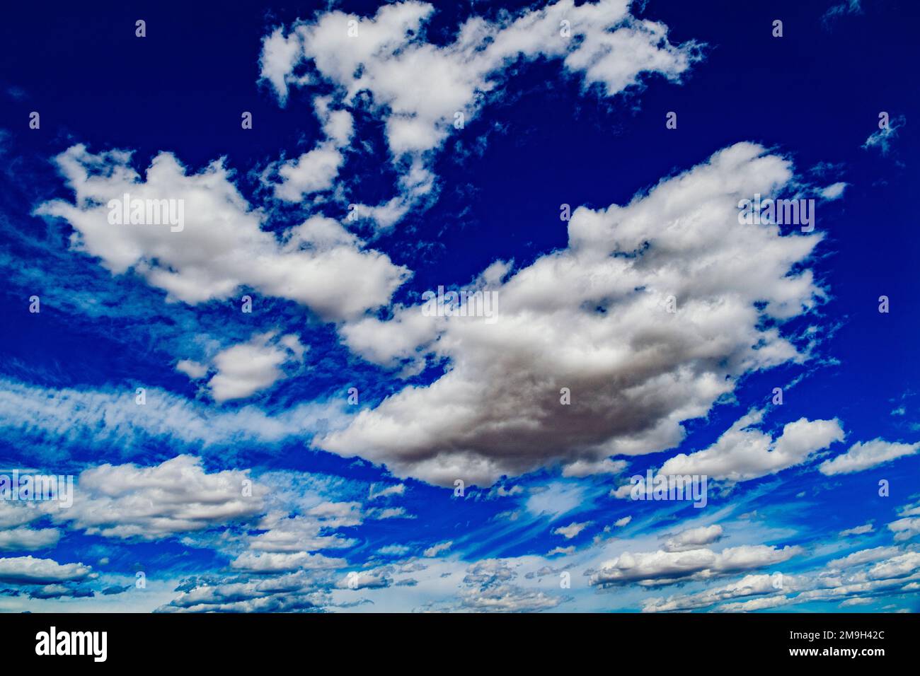 Fluffy clouds in blue sky Stock Photo - Alamy
