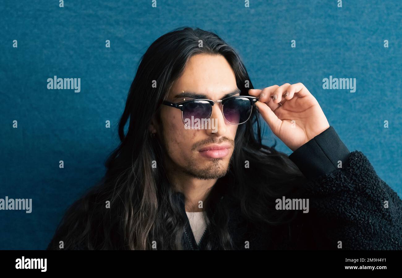 Portrait of young man with glasses and long hair Stock Photo - Alamy