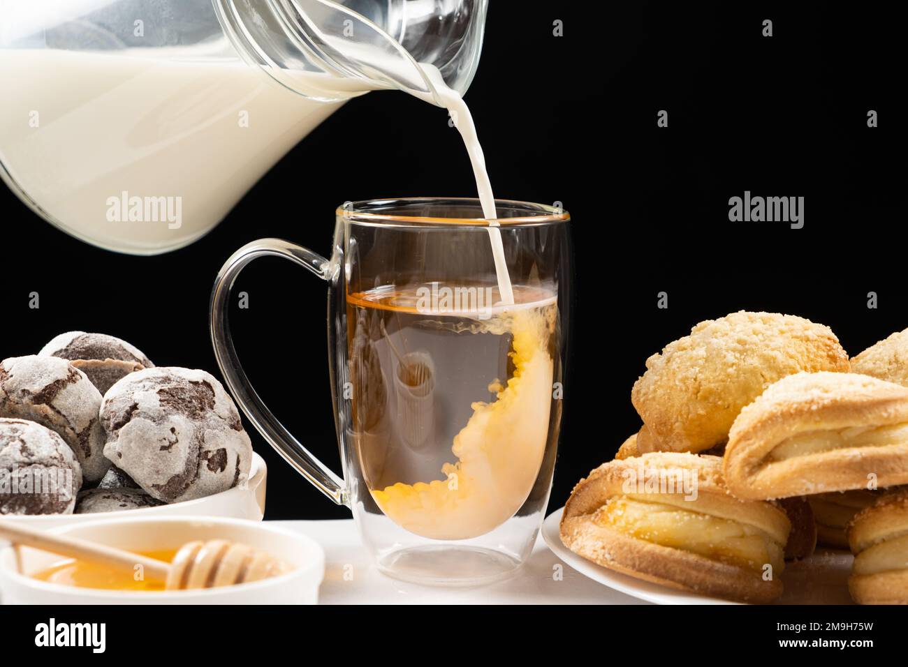 Making milk tea milk from a glass jug is poured into black English