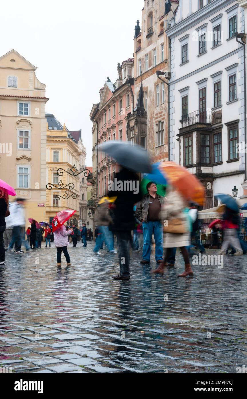 Pedestrians with umbrellas walking on wet cobblestones in old town, Prague, Czech Republic Stock Photo