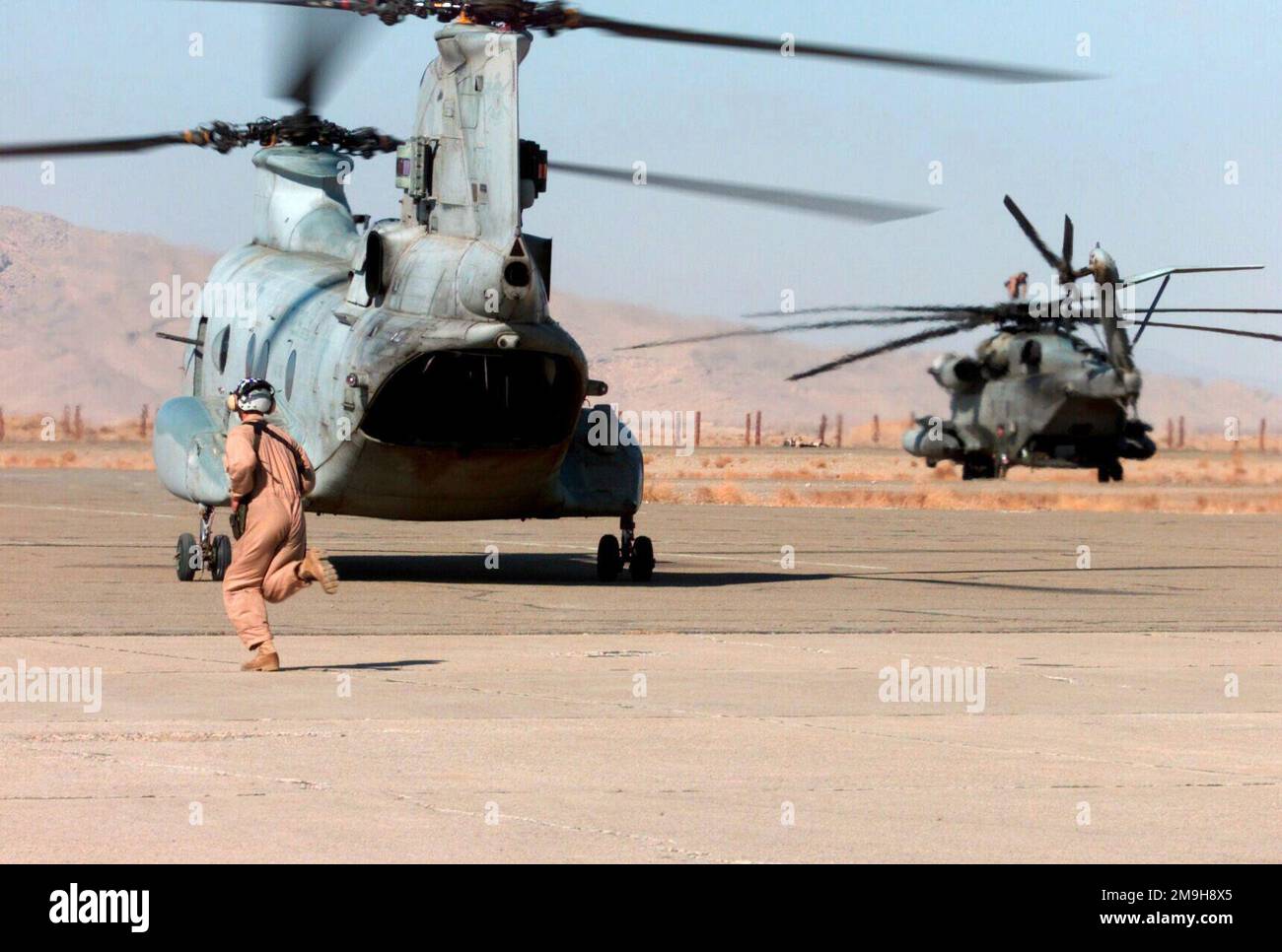 A Marine crew chief runs alongside a CH46 helicopter with Helicopter