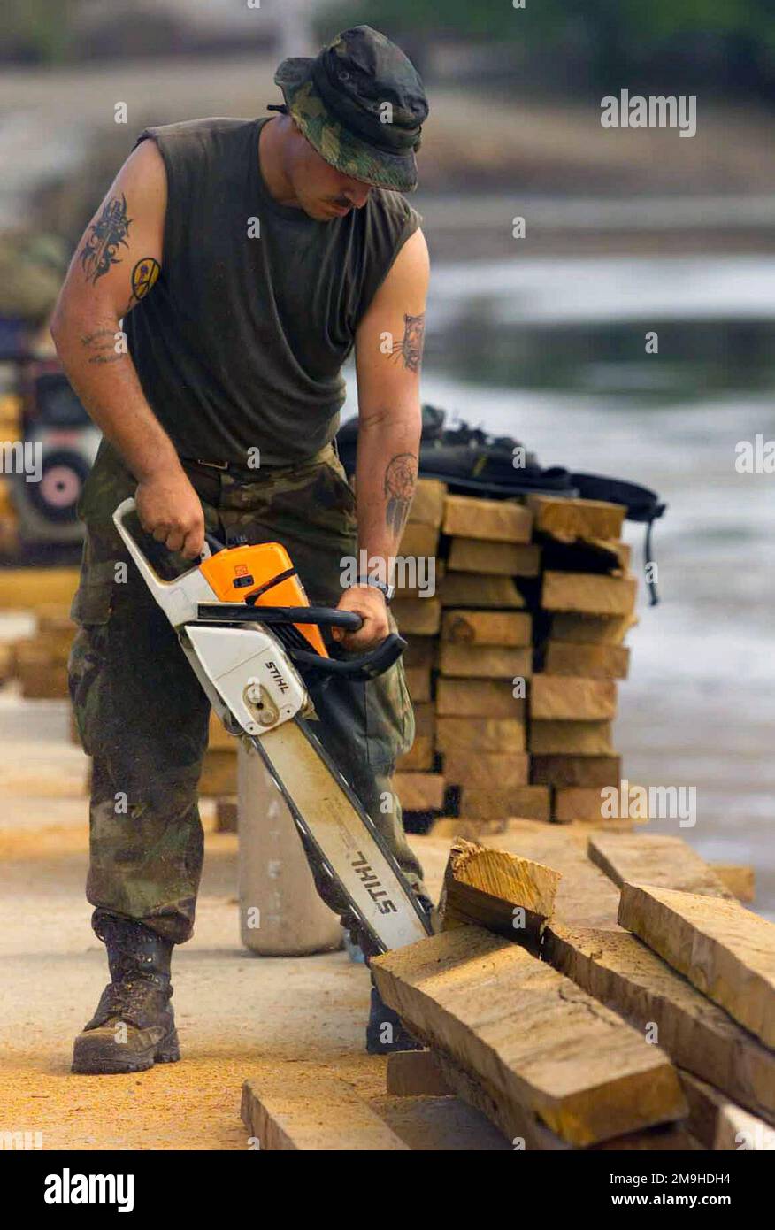 Lance Corporal Martin T. Couch, Combat Engineer, 1ST CEB (Combat Engineer Battalion), Alpha Co, 2nd Platoon, BLT 1/4 (Battalion Landing Team), 13th Marine Expeditionary Unit (Special Operations Capable) (MEU (SOC)), Camp Pendleton, California, cuts wood to be used on the bridge into Faza. The bridge is being built as part of community relations during Exercise EDGE MALLET 02 in Faza, Kenya. Subject Operation/Series: EDGE MALLET 02 Base: Faza State: Coast Country: Kenya (KEN) Scene Major Command Shown: 13 MEU Stock Photo