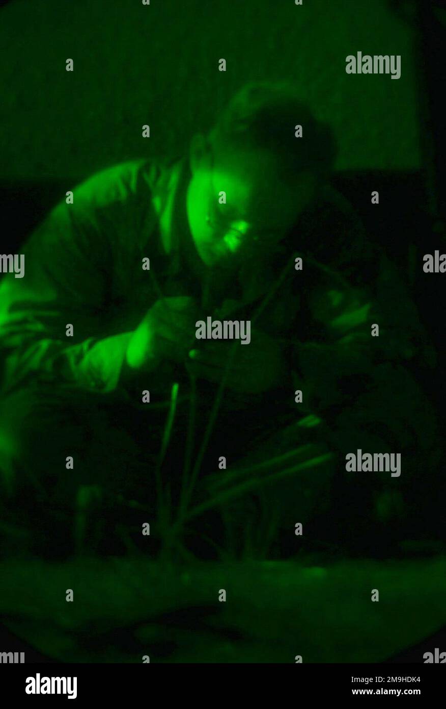 As seen through the green glow of a night scope, Lance Corporal James D. Matkin, Tanker, with BLT 1/4 (Battalion Landing Team), 13th Marine Expeditionary Unit (Special Operations Capable) (MEU (SOC)) writes a letter using only the light emanating from the Command Post in Kenya, Africa. The Marines are there as part of Exercise EDGED MALLET 02. Subject Operation/Series: EDGED MALLET 02 Base: Command Post State: Coast Country: Kenya (KEN) Scene Major Command Shown: 13 MEU Stock Photo