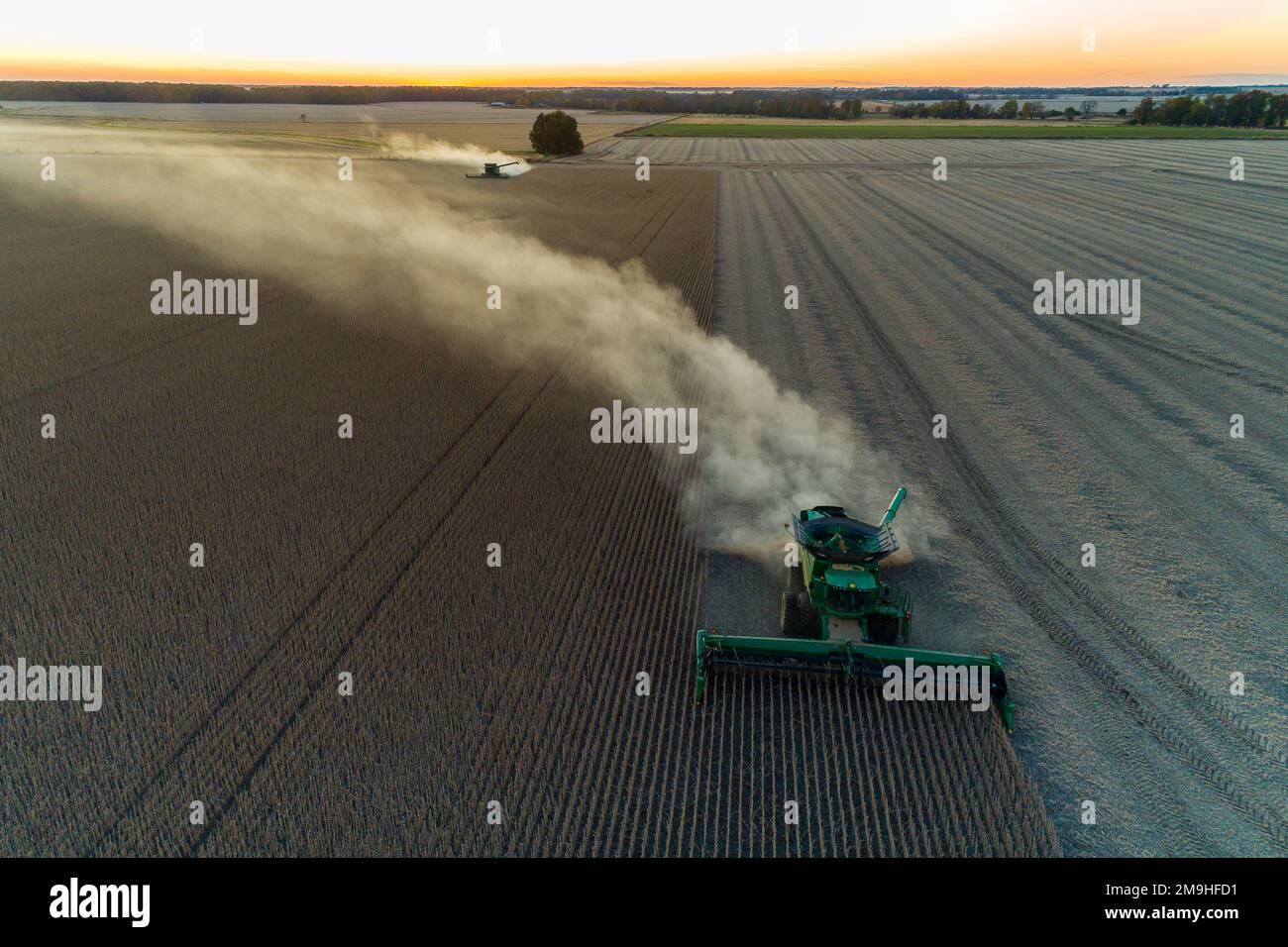 Aerial view of combines harvesting soybeans at sunset, Marion County, Illinois, USA Stock Photo