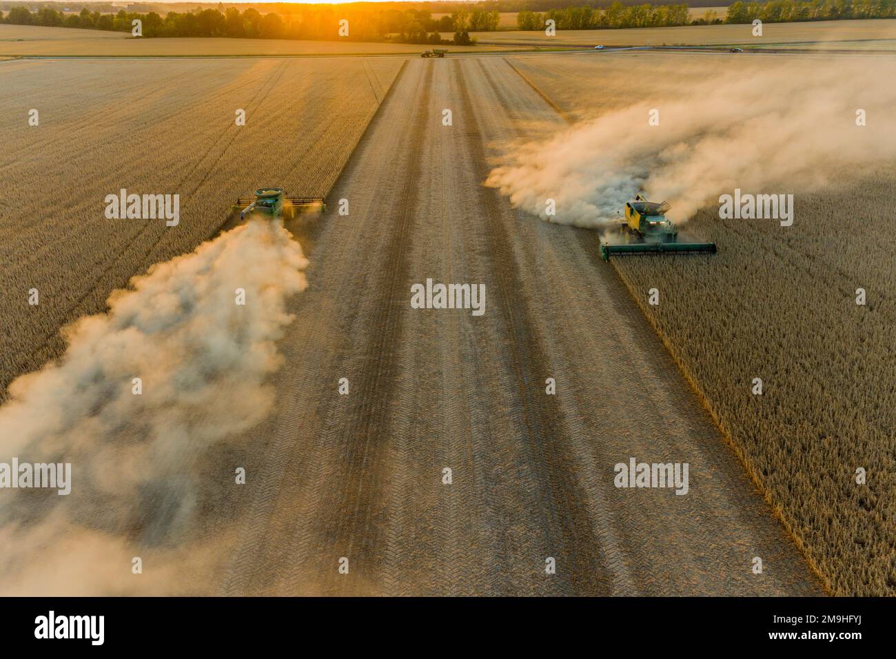 Aerial view of combines harvesting soybeans at sunset, Marion County, Illinois, USA Stock Photo