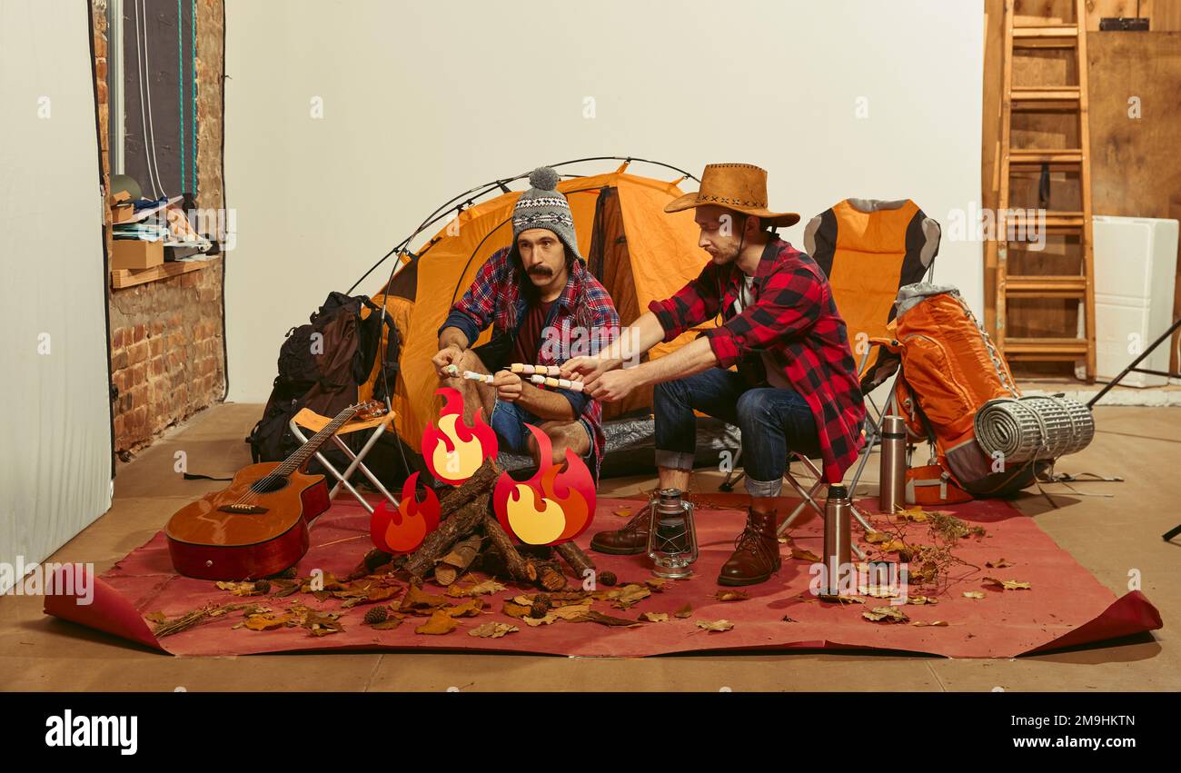 Doing marshmallows over fake fire. Two men imagining, recreating ...