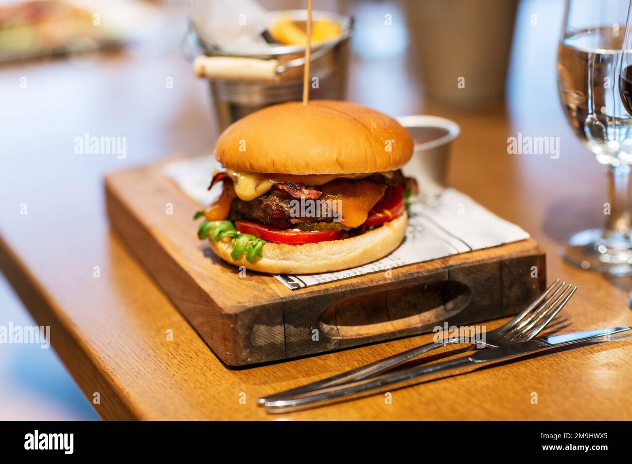 close up of burger on wooden board at restaurant Stock Photo