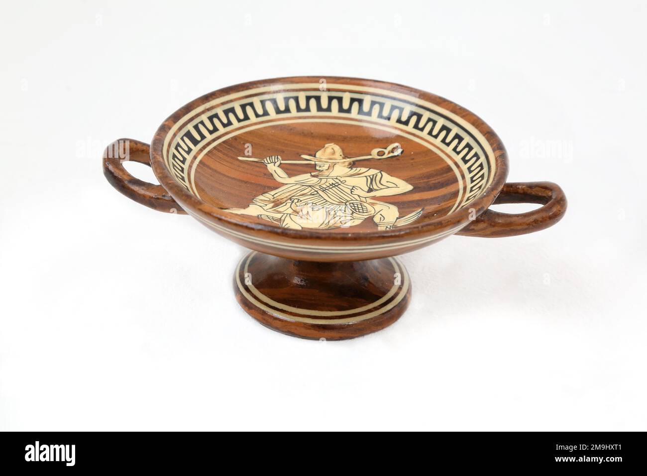 Kylik - a popular Greek drinking wine cup with a depiction of the Greek Messenger God Hermes with his Winged Feet and holding his Lyre and Kerykeion/ Stock Photo