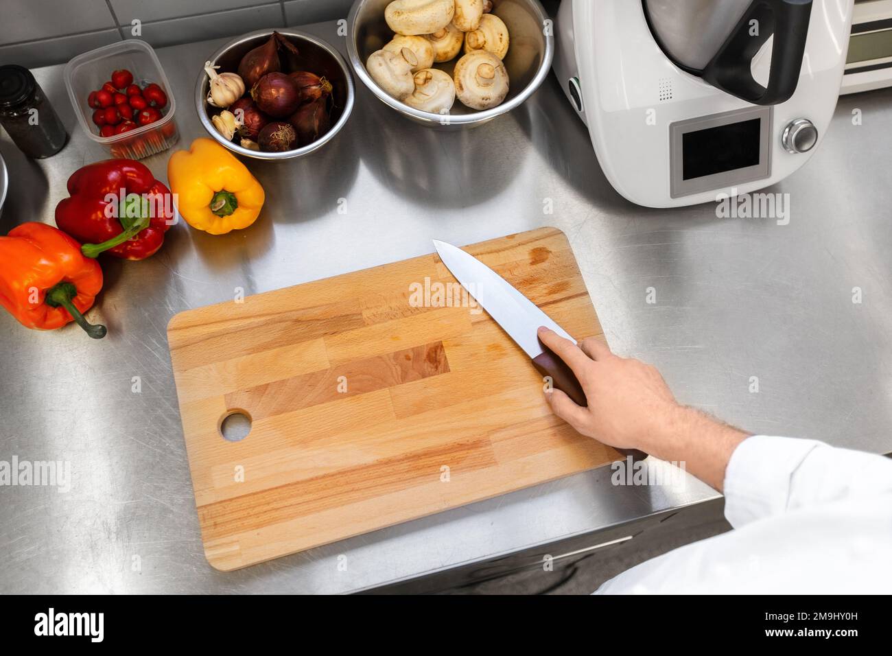 close up of chef with knife at restaurant kitchen Stock Photo