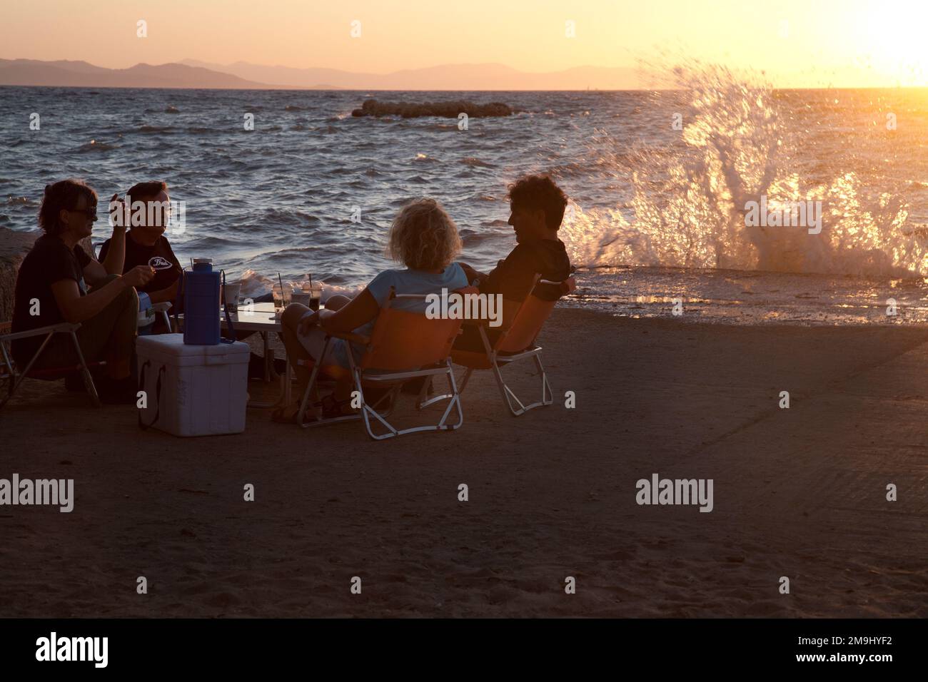 friends having picnic on beach at sunset kavouri vouliagmeni athens