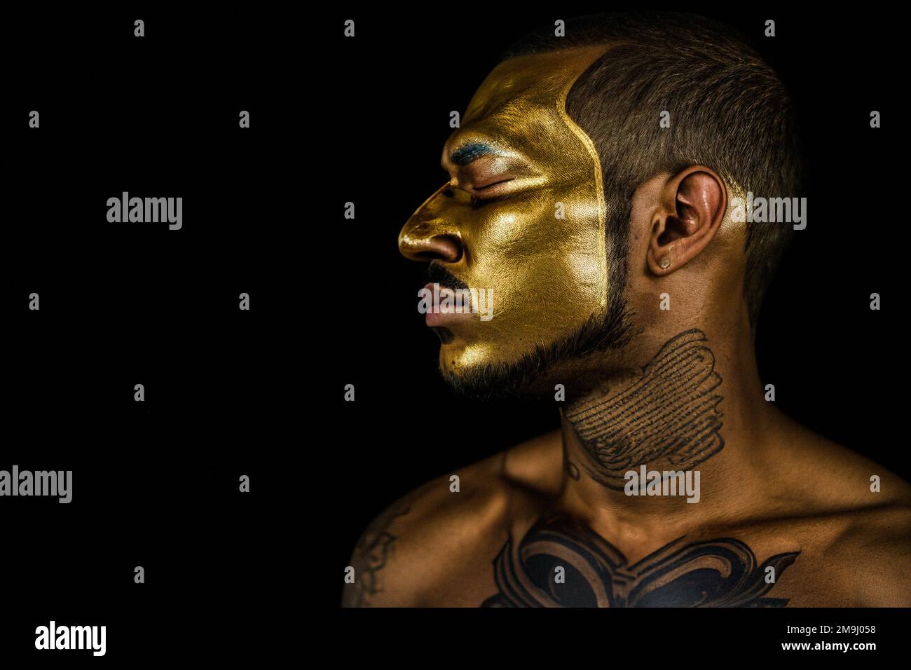 Young man in gold makeup, on a black background. Photography 3d