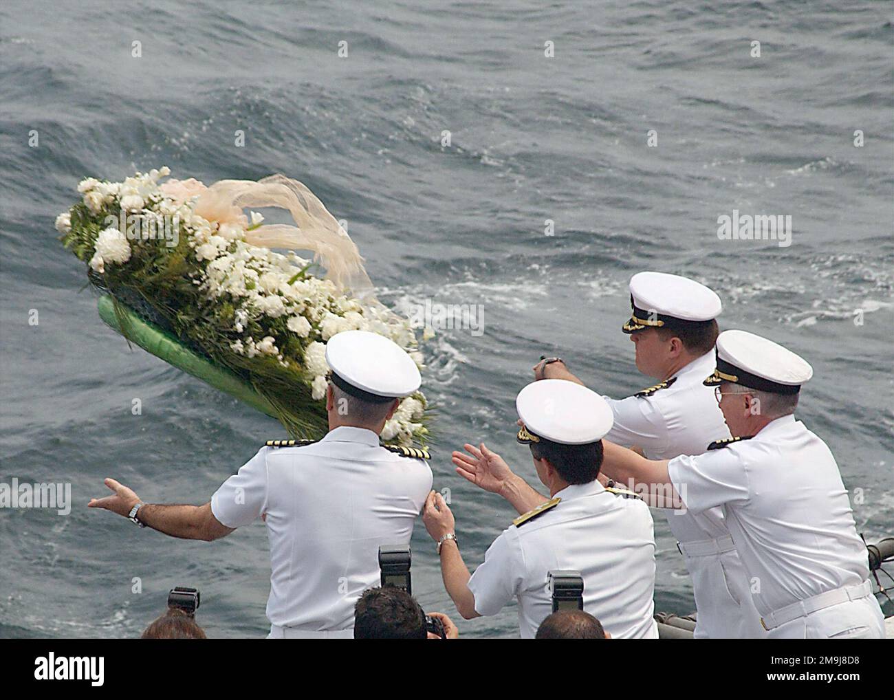 020911-N-2329T-001. [Complete] Scene Caption: US Navy (USN) members of the USN Nimitz Class Aircraft Carrier USS GEORGE WASHINGTON (CVN 73) crew and air wing toss a wreath into the sea during a memorial ceremony commemorating the one-year anniversary of the 9/11 terrorist attacks. Tossing the wreath are USN Captain (CAPT) Martin J. Erdossy (left), Commanding Officer; USN Rear Admiral (RADM) (Upper half) Joseph A. Sestak Jr., GW Battle Group Commander; USN CAPT Dana R. Potts, Carrier Air Wing (CAW) 17 Commander; and USN CAPT Gerald D. Roncolato (right), Commander of Destroyer Squadron 26. A yea Stock Photo