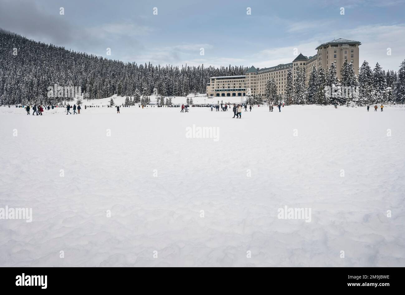 A crowd of unrecognizable people recreate on frozen Lake Louise in Banff National Park, Alberta, Canada Stock Photo