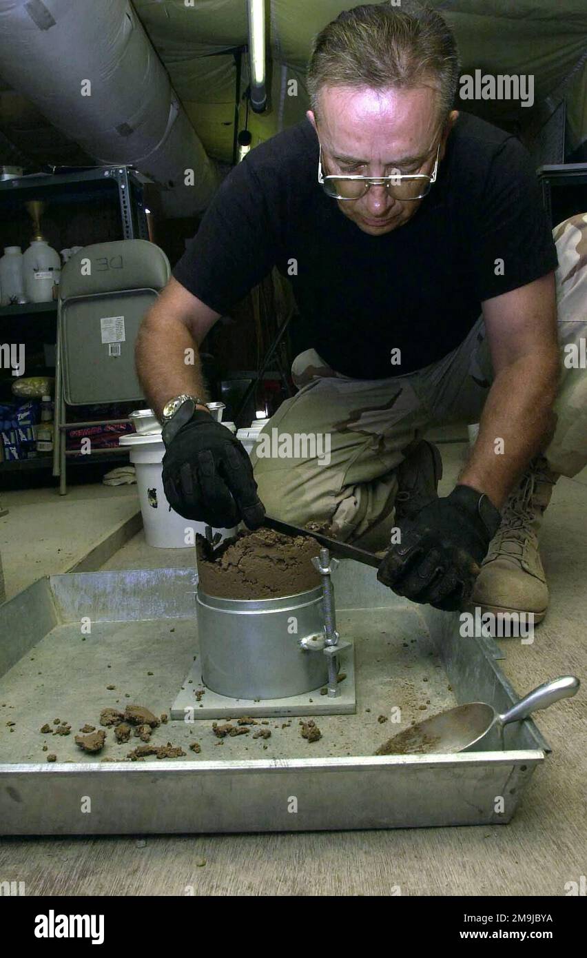US Air Force (USAF) SENIOR MASTER Sergeant (SMSGT) Terry Wickman, with the 819/219th Expeditionary Red Horse Squadron, levels a soil sample prior to weighing and testing it at this forward-deployed location (FDL) in the Arabian Gulf region, in support of ENDURING FREEDOM. Country: Unknown Stock Photo