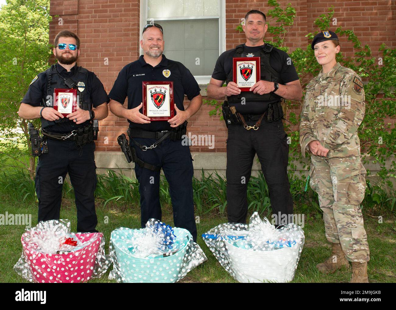 Winners of “Battle of the Paws” K-9 competition hosted by the 55th Security Forces Squadron pose for photograph at Offutt Air Force Base, Neb., May 19, 2022. (From left) Third place Officer Alex Klement, Council Bluffs Police Department, first place Officer Ken Mcclure, Council Bluffs Police Department, second place Officer Jay Weininger, Douglas County Sheriff’s Department, and Senior Airman Casi Smith, 55th Security Forces Squadron military working dog handler and competition coordinator. Stock Photo