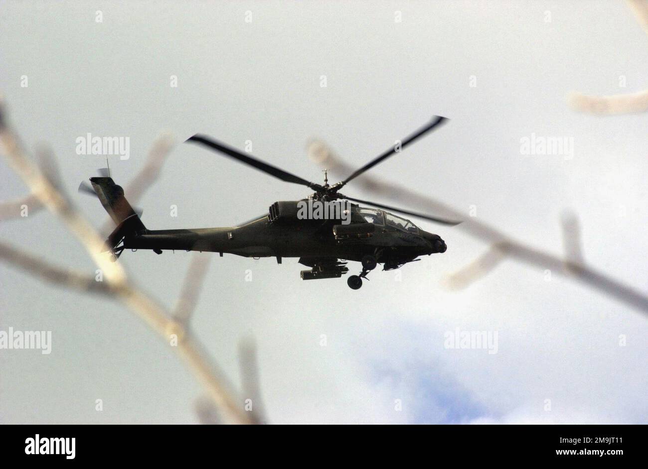 A US Army (USA) AH-64A Apache Helicopter flies over the city of Naray ...