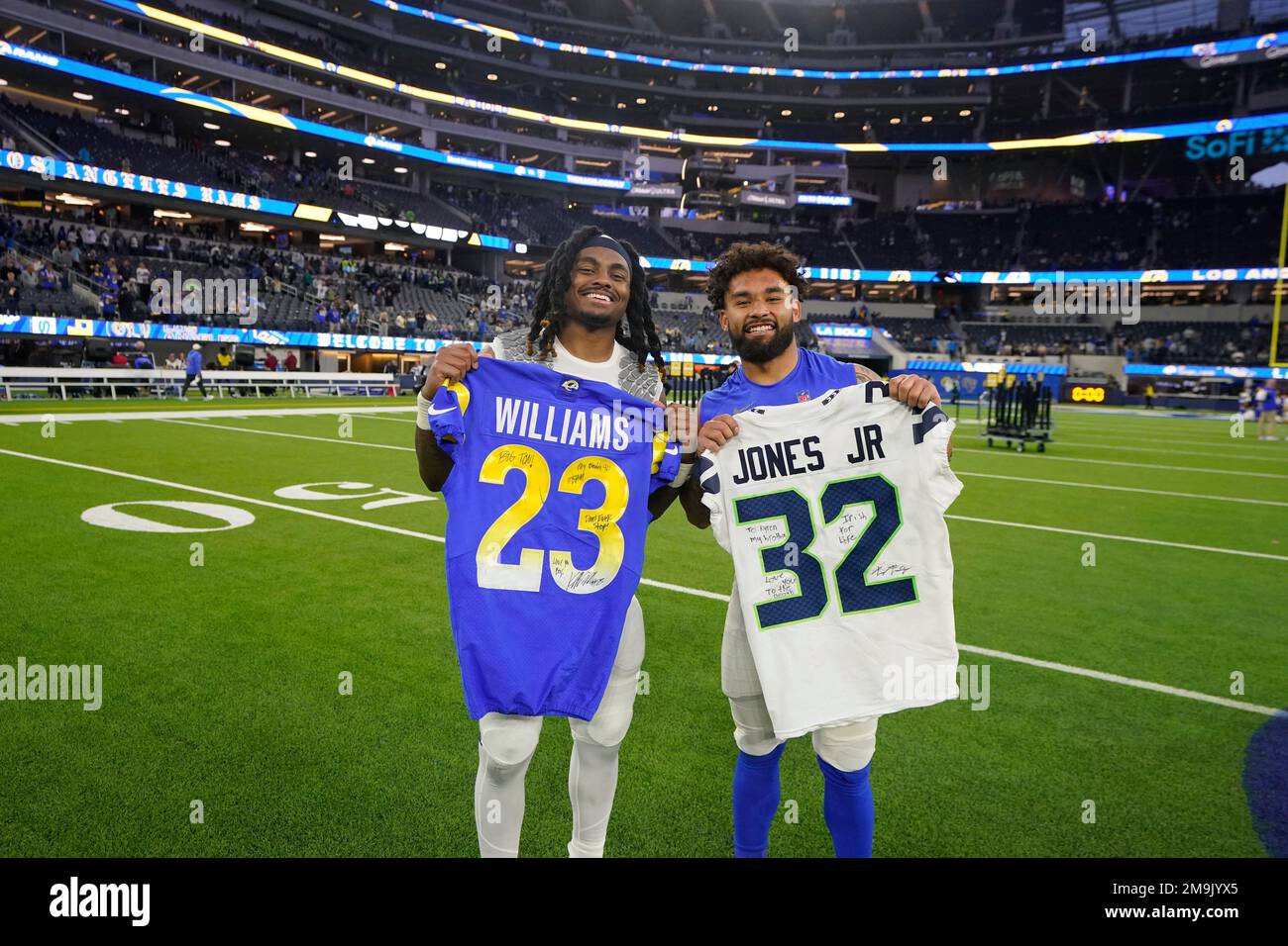 Seattle Seahawks running back Tony Jones Jr. (32) and Los Angeles Rams  running back Kyren Williams (23) hold up their jerseys following an NFL  football game Sunday, Dec. 4, 2022, in Inglewood,