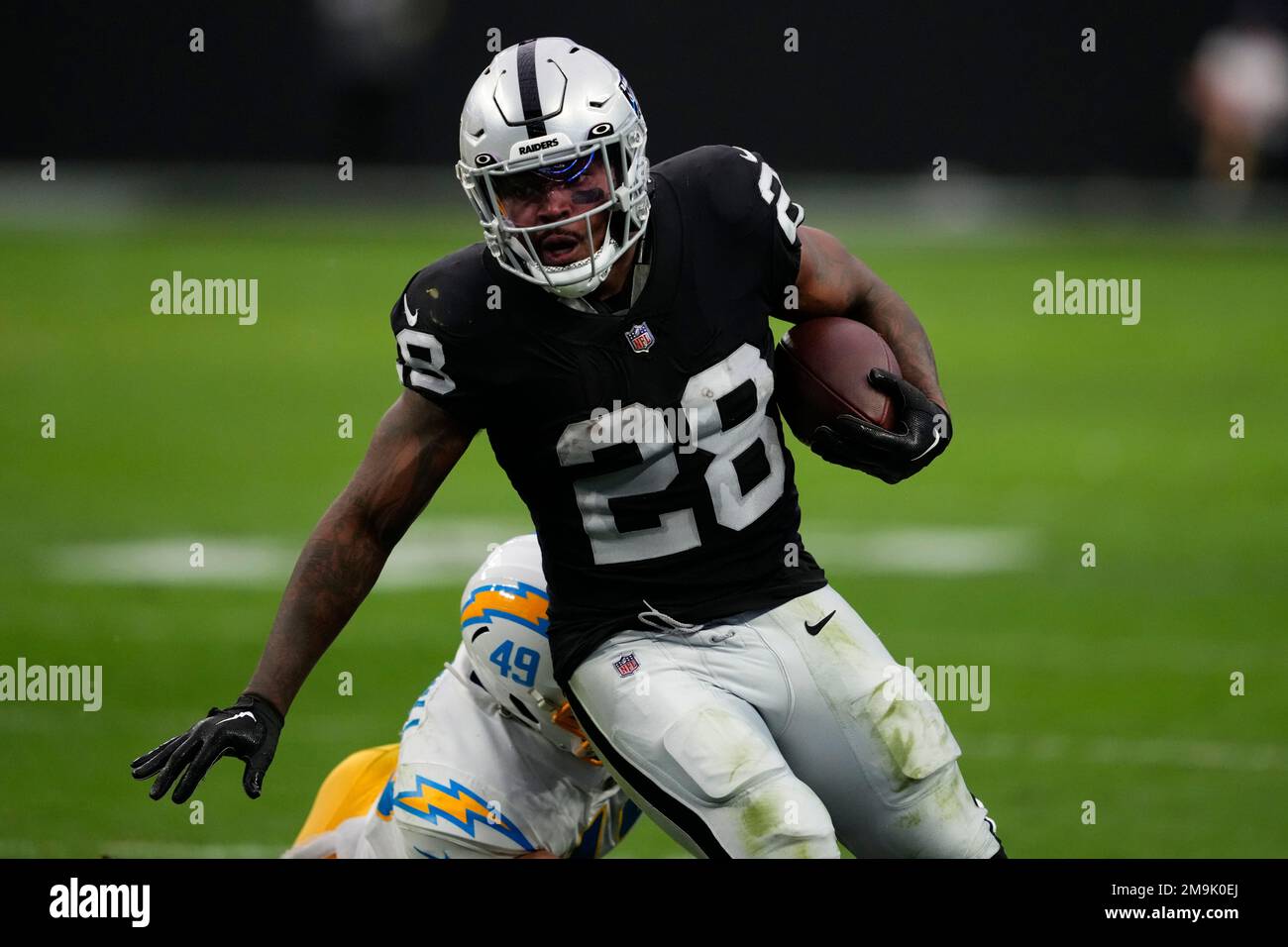 Las Vegas Raiders running back Josh Jacobs (28) carries against Los Angeles  Chargers linebacker Drue Tranquill (49) during the first half of an NFL  football game, Sunday, Dec. 4, 2022, in Las