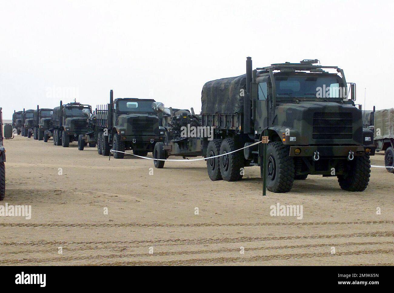 A marshalling yard is filled with MK-23 trucks and M198 155mm Towed ...