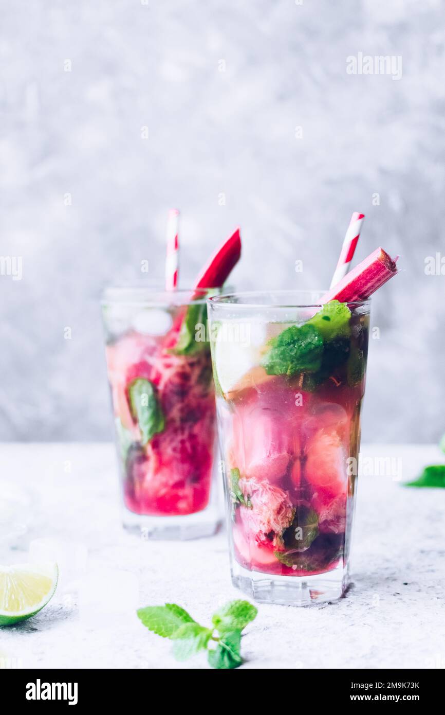 Summer refreshing drink with rhubarb, lime and mint. Rhubarb lemonade. Glass with fresh cool spring rhubarb mojito cocktail. Copy space. Stock Photo