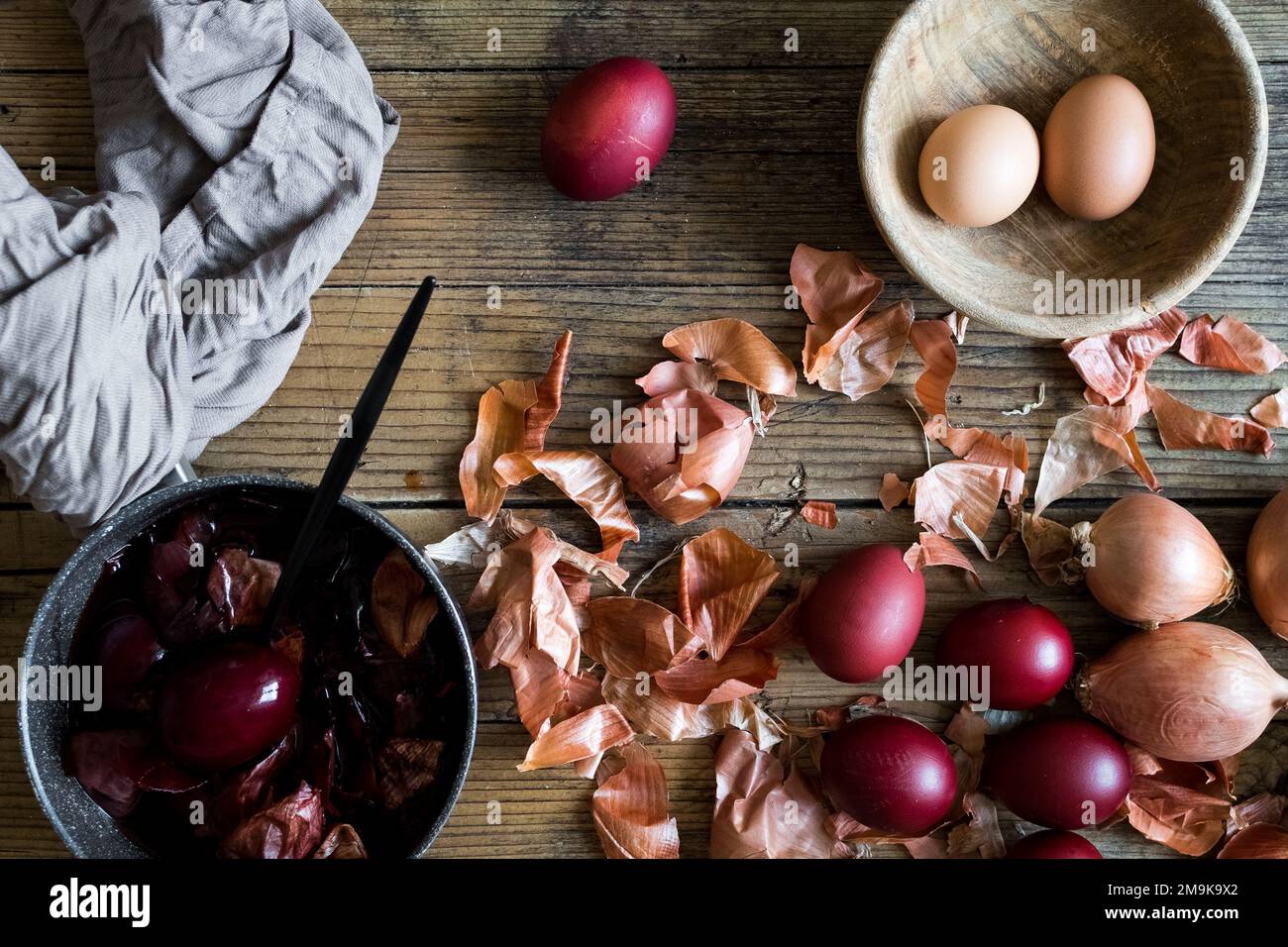 Dyed Easter eggs painted with natural dye onion on rustic wooden background. Process of dyeing eggs with natural paints for Easter. Natural ecological Stock Photo