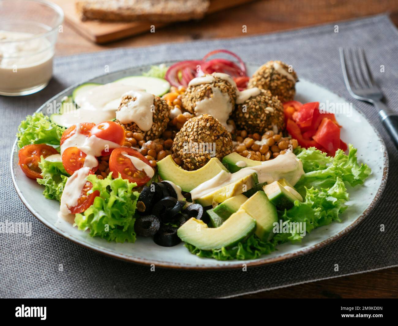 Healthy mixed salad as dinner with home made falafel balls and a tahini dressing. Stock Photo