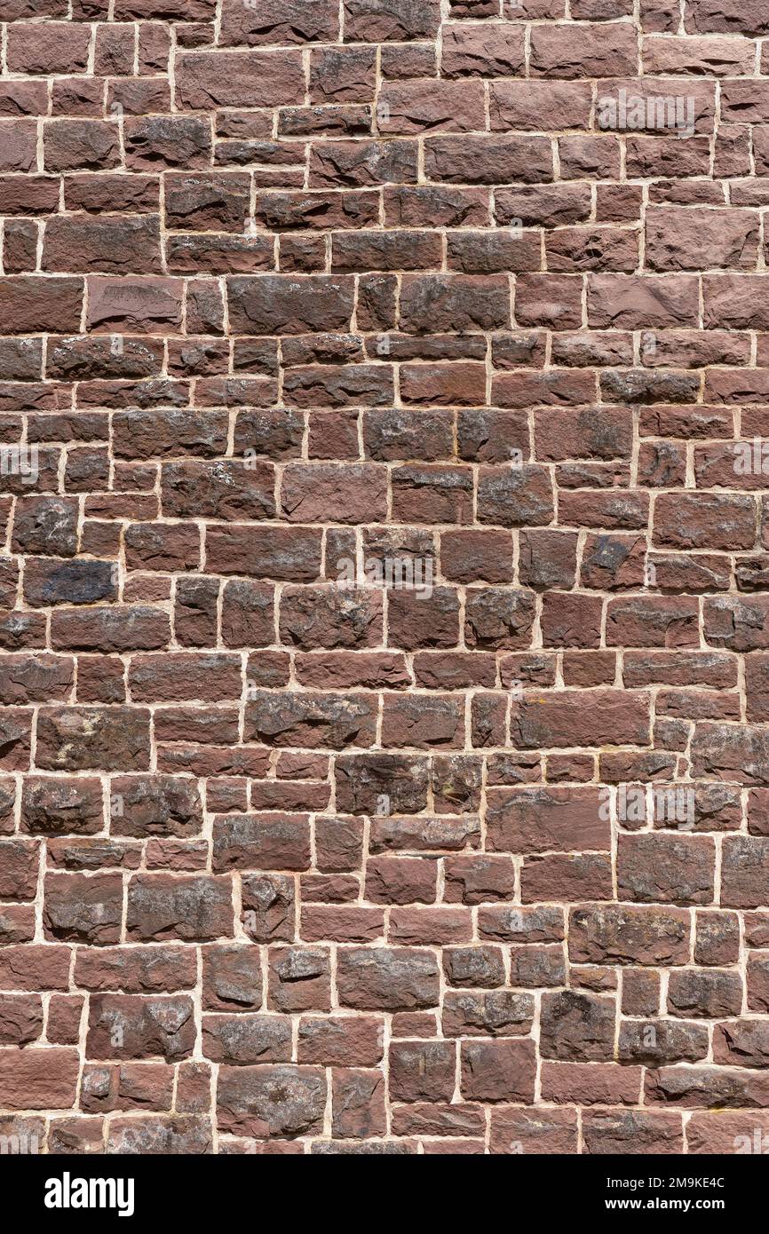 Old wall made of many red sandstones in close-up portrait format Stock Photo