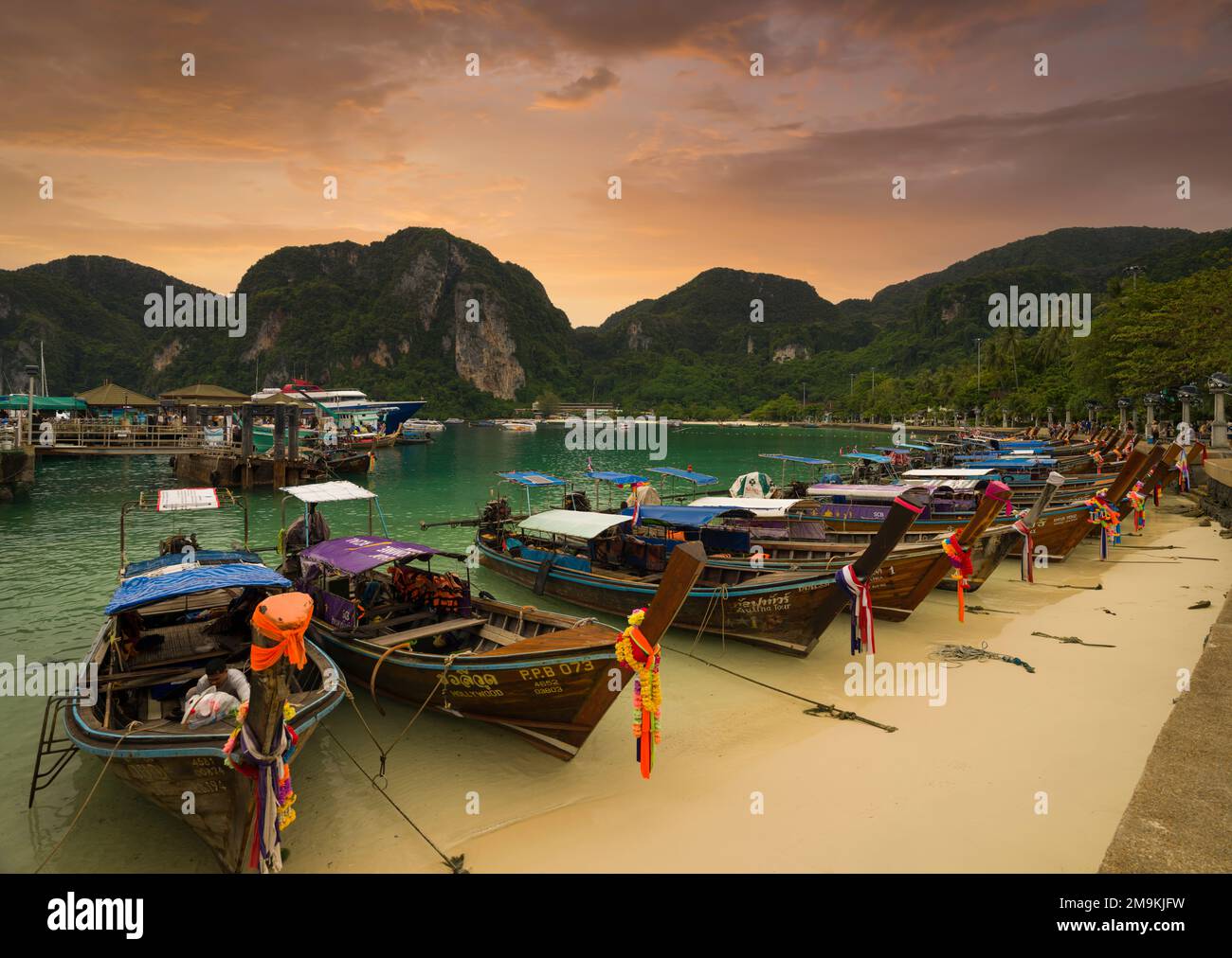 Phi Phi Island, Krabi, Thailand. December 3, 2022. The famous Ton Sai beach at sunset. Traditional tour boats on the beach and beautiful bay view. Stock Photo
