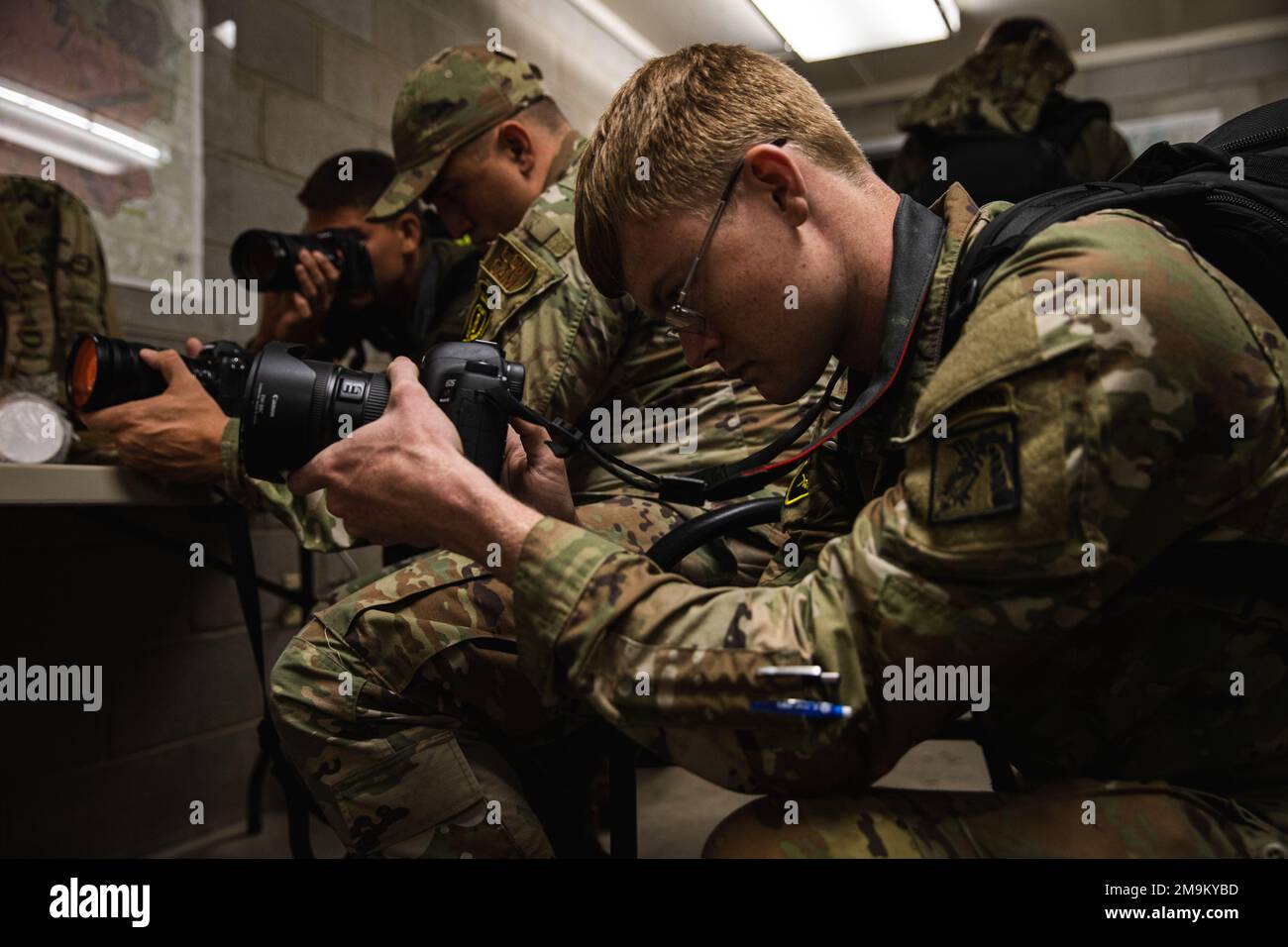 U.S. Army Spc. Jameson Harris, a visual information specialist assigned to 22nd Mobile Public Affairs Detachment, takes a photo of another competitor during the Day 2 Night Land Navigation event of the 2022 Spc. Hilda I. Clayton Best Combat Camera Competition at Fort A.P. Hill, Virginia, May 20, 2022. The annual multi-day competition tests the tactical and technical proficiency of visual information and public affairs specialists across the DOD and participating international competitors. Stock Photo