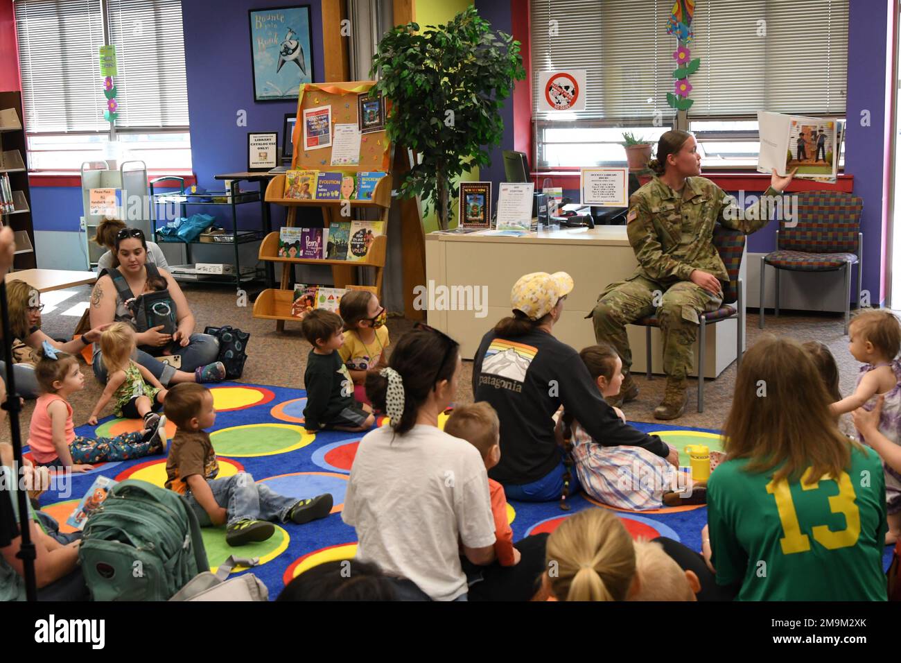 Spc. Daphne Duke, with 8th Military Police Detachment, 91st MP Battalion, reads a children’s book at McEwen Library on May 20 for a special “Storytime with Military Police” event. (Photo by Mike Strasser, Fort Drum Garrison Public Affairs) Stock Photo