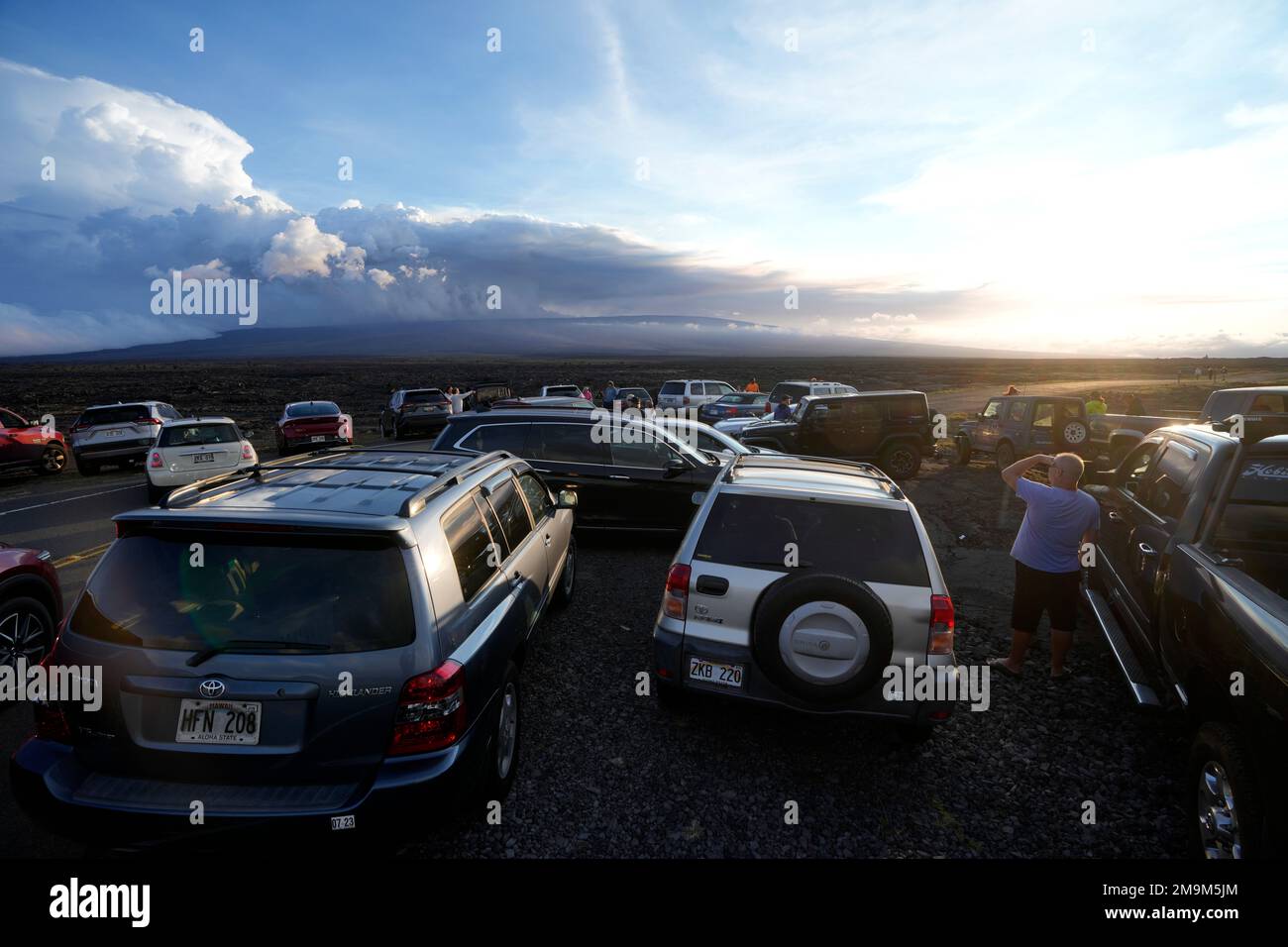 An overflow of cars sit in a parking lot near the Mauna Loa volcano as it erupts Wednesday, Nov