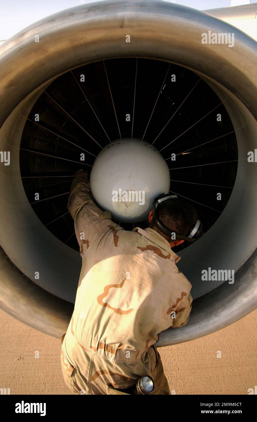 US Air Force (USAF) Technical Sergeant (TSGT) Juan Montez, Jet Engine Mechanic, 363rd Expeditionary Aircraft Maintenance Squadron (EAMXS), checks the fan blades on a USAF E-3C Sentry Airborne Warning And Controls System (AWACS) aircraft engine at a forward deployed location in Southwest Asia, during Operation SOUTHERN WATCH. Subject Operation/Series: SOUTHERN WATCH Country: Unknown Stock Photo