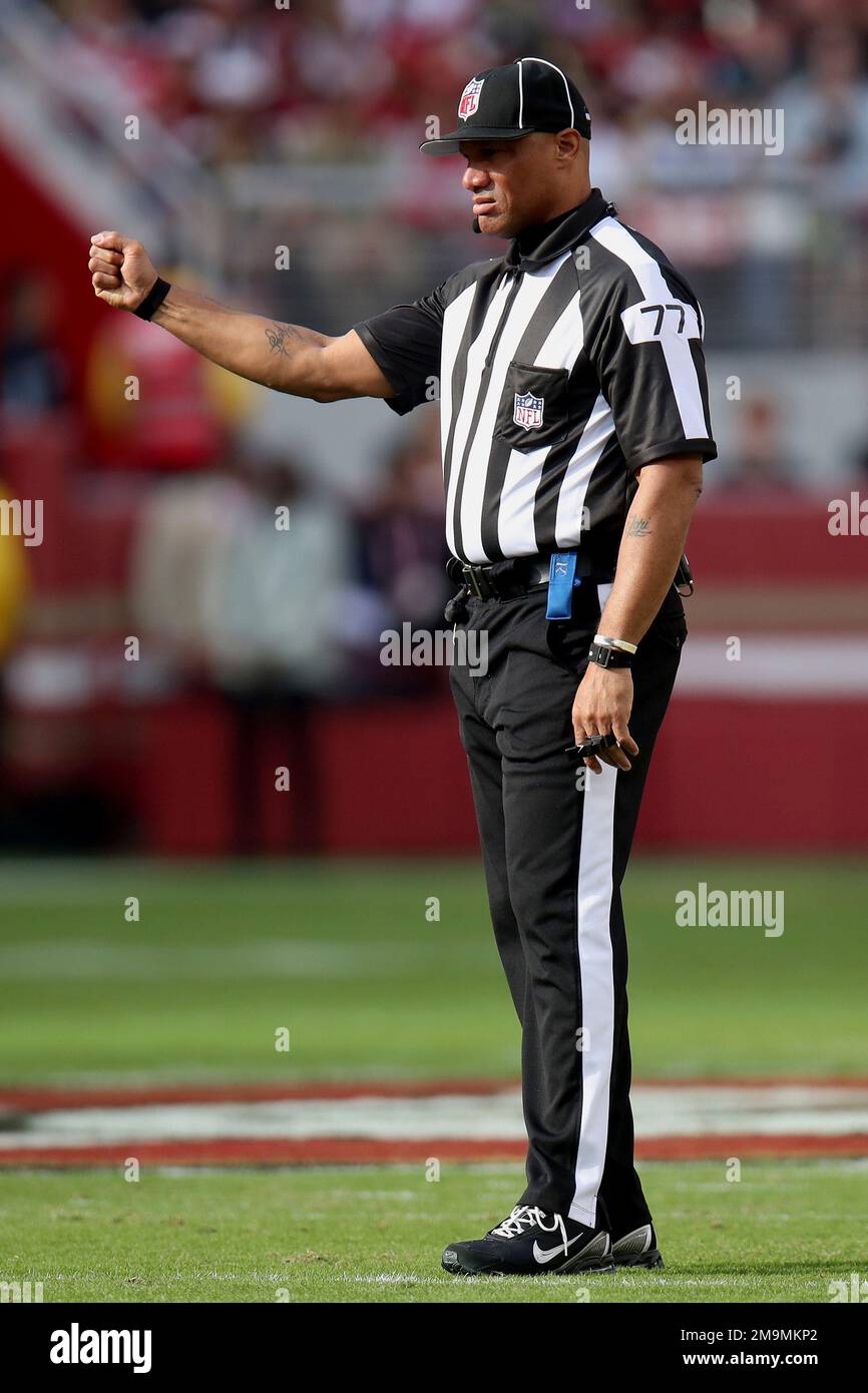 Umpire Terry Killens (77) signals during an NFL football game