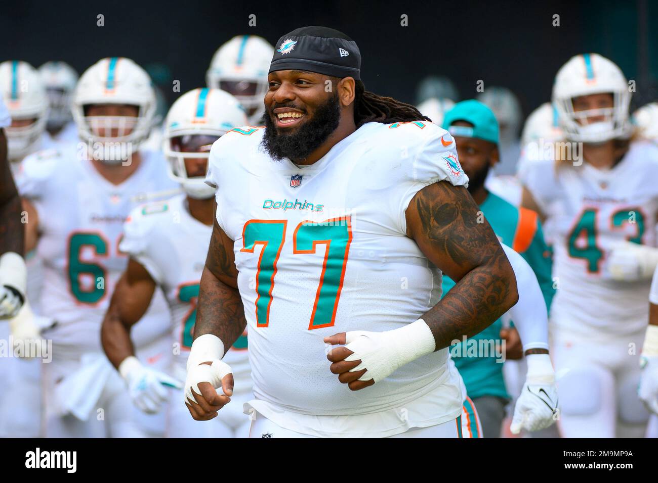 Miami Dolphins defensive tackle John Jenkins (77) smiles as he runs onto  the field before an NFL football game against the Houston Texans, Sunday,  Nov. 27, 2022, in Miami Gardens, Fla. (AP