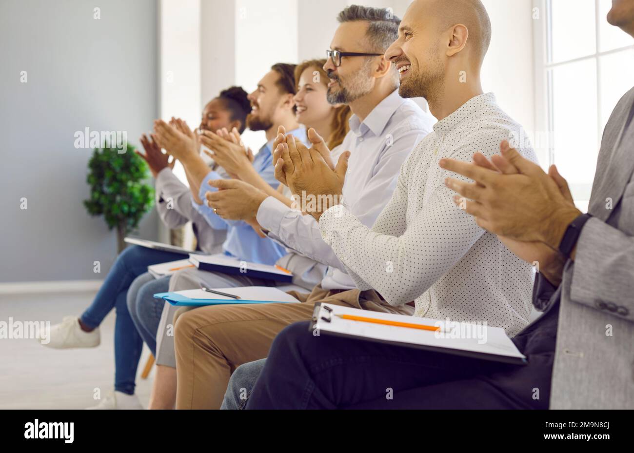 Happy audience sitting in row at professional business seminar