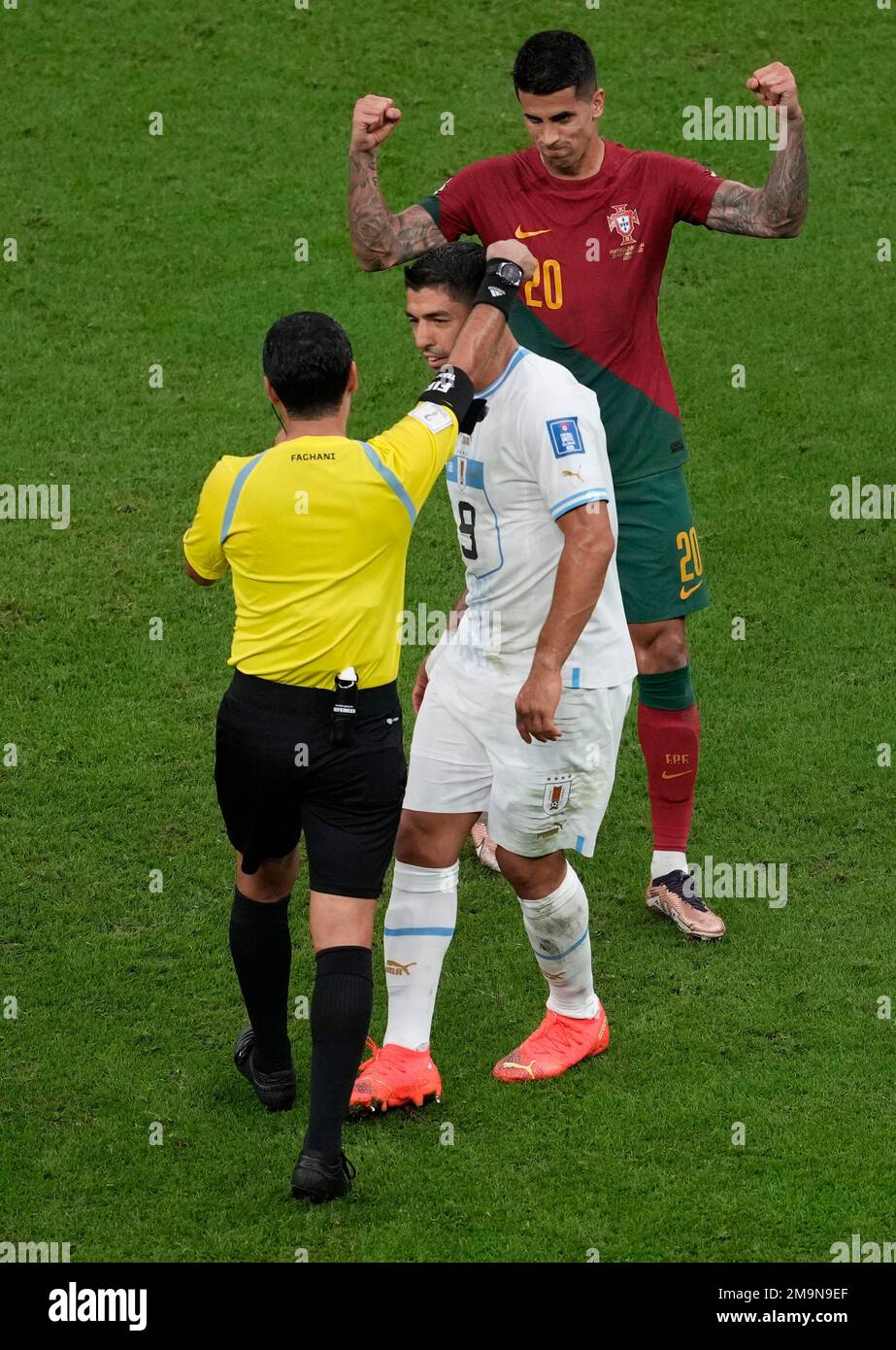 Uruguay's Luis Suarez, center, argues with Referee Alireza Faghani