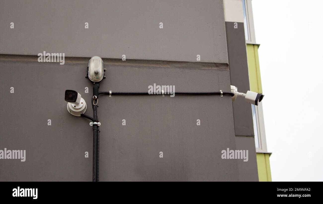 Surveillance cameras on the wall of a highrise apartment building