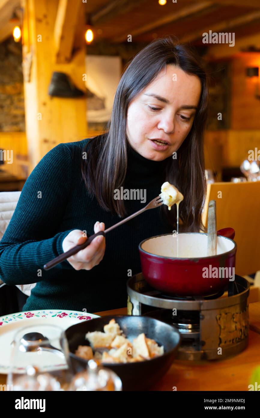 Woman eating tradicional Swiss dish fondue Stock Photo Alamy
