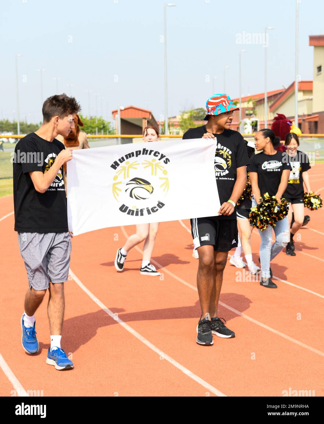 Humphreys High School students carry a flag around the Humphreys Middle School track during the