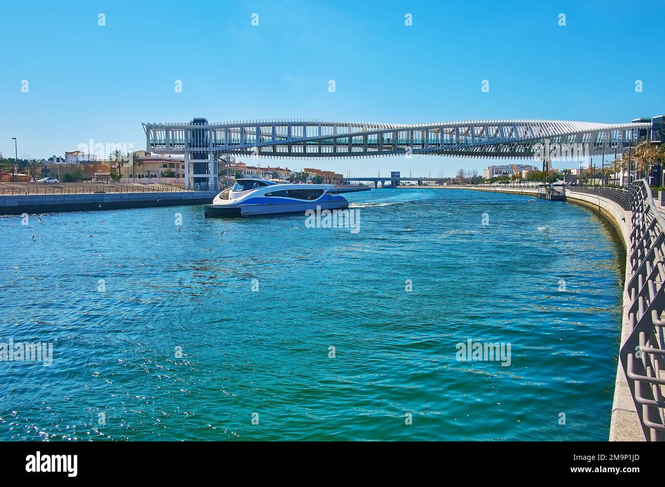 The ferry floats under the futuristic construction of the Water Canal