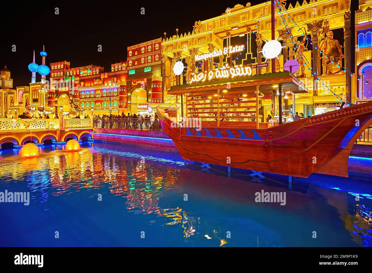 DUBAI, UAE - MARCH 6, 2020: The brightly illuminated trade pavilions of Iran, Yemen, Kuwait of Global Village Dubai behind the canal with decorative w Stock Photo