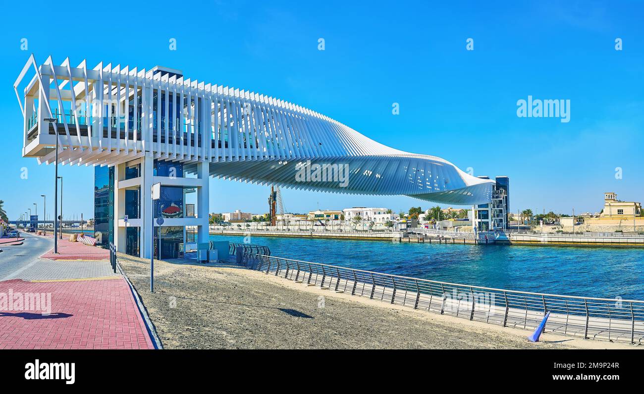Embankment of Dubai Water Canal with a view on Water Canal Footbridge, also named Twisted Bridge, Dubai, UAE Stock Photo