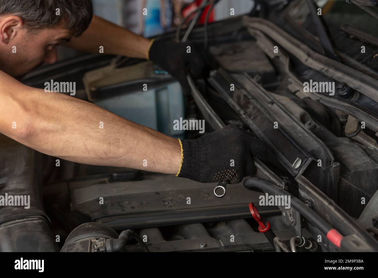 Car service, repair, maintenance and people concept - auto mechanic looking for a malfunction in the car engine. Mechanic hands checking up of service Stock Photo