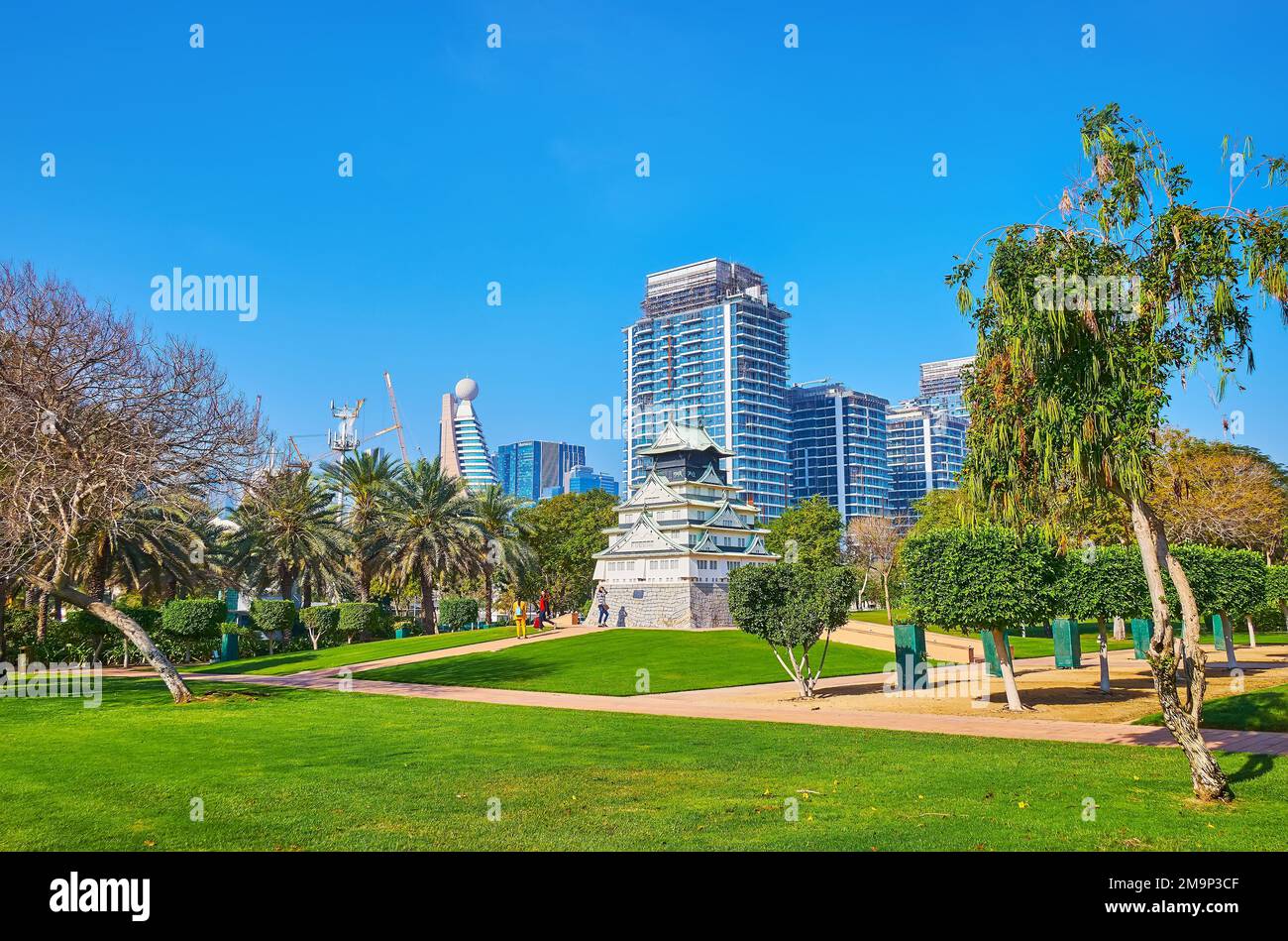 DUBAI, UAE - MARCH 6, 2020: Beautiful green Zabeel Park with model of Osaka Castle, modern glass buildings of Park Gate Residence Towers and Etisalat Stock Photo