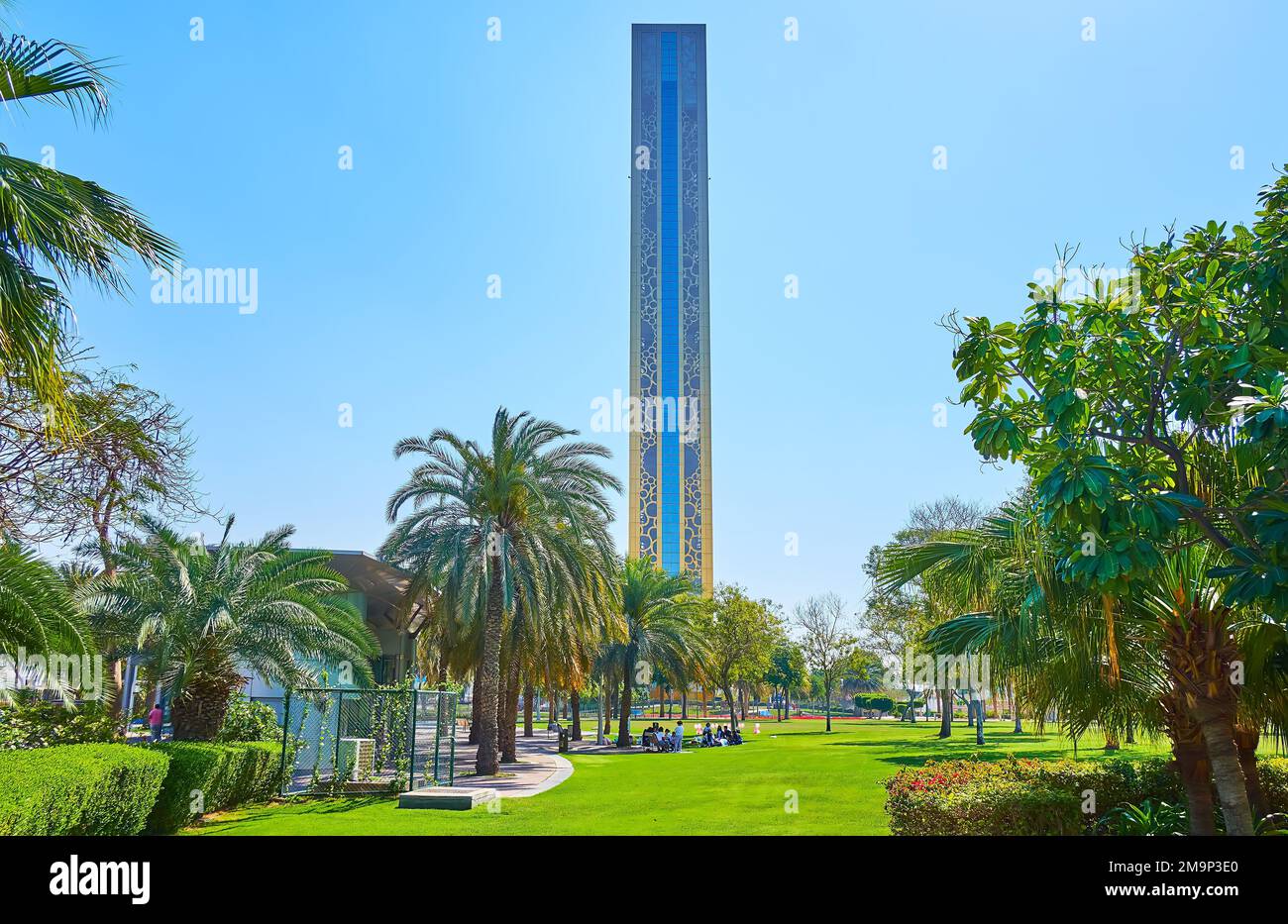 The beautiful Zabeel Park with palms, topiary bushes, green lawn and a ...